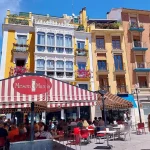 Busy café terraces in Plaza de las Flores, Murcia, on a sunny day